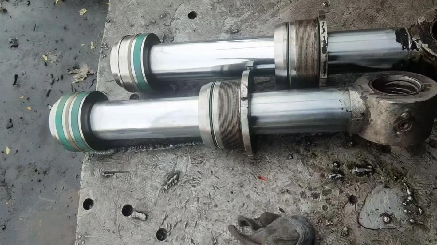 Close-up of pitted hydraulic cylinder rod showing chrome damage and oil leakage